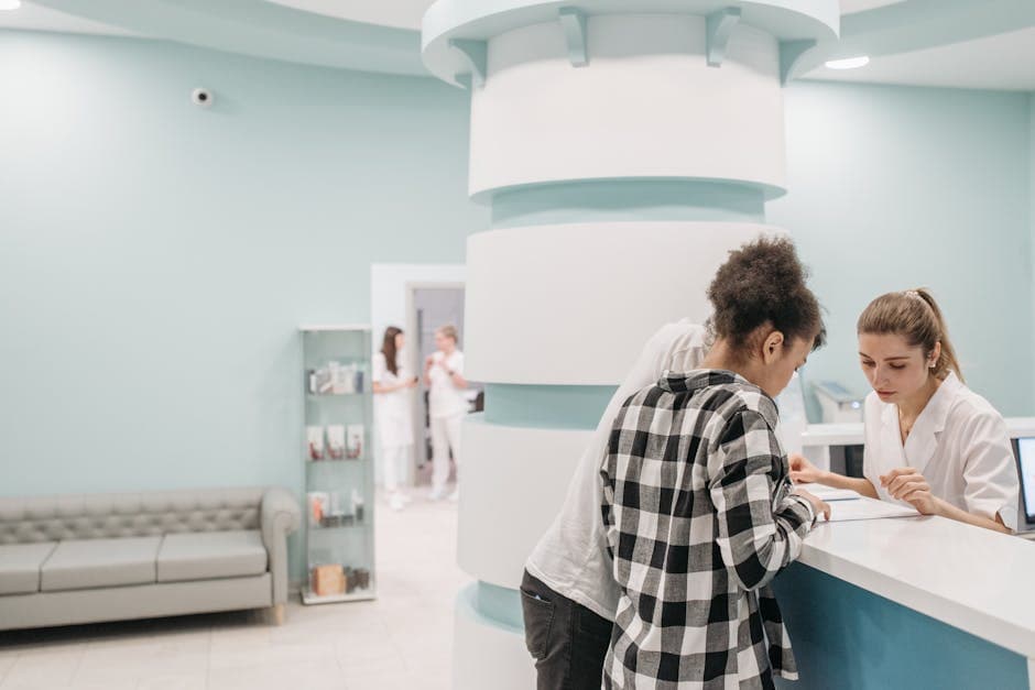 Clinic receptionist answering a patient call at the front desk